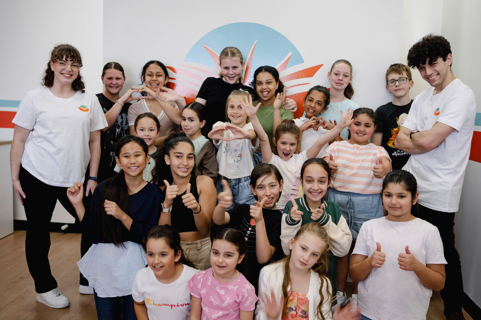 a group of children are posing for a picture and one girl is wearing a champion shirt