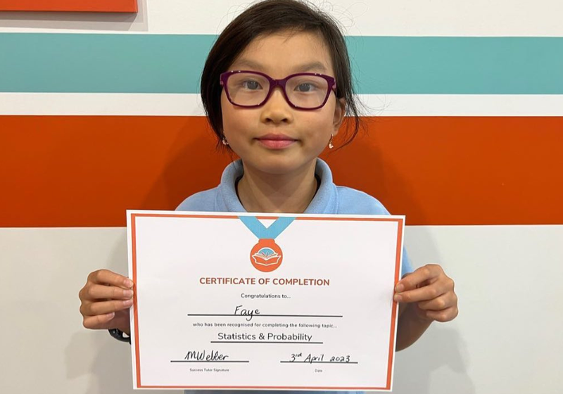 Student holding a Success Tutoring certificate
