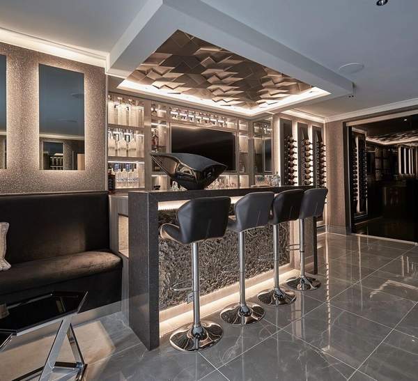Bespoke home bar with illuminated shelving and marble worktop
