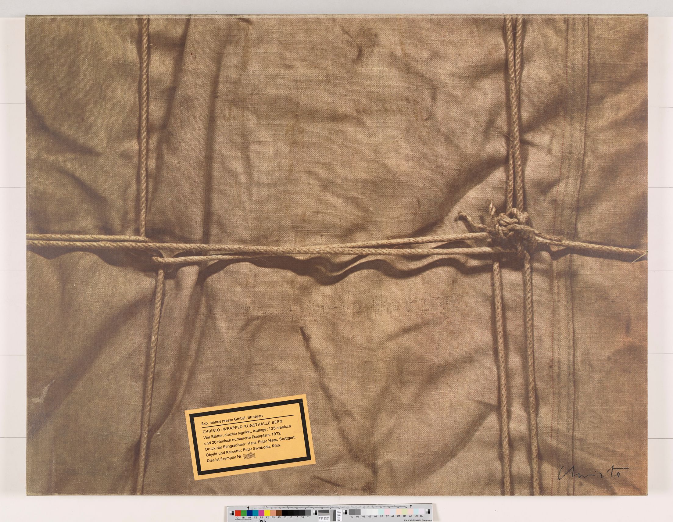 Fotografie Nahaufnahme. Nylon mit Seil und Knoten. Ein gelbe Aufkleber mit Text. 