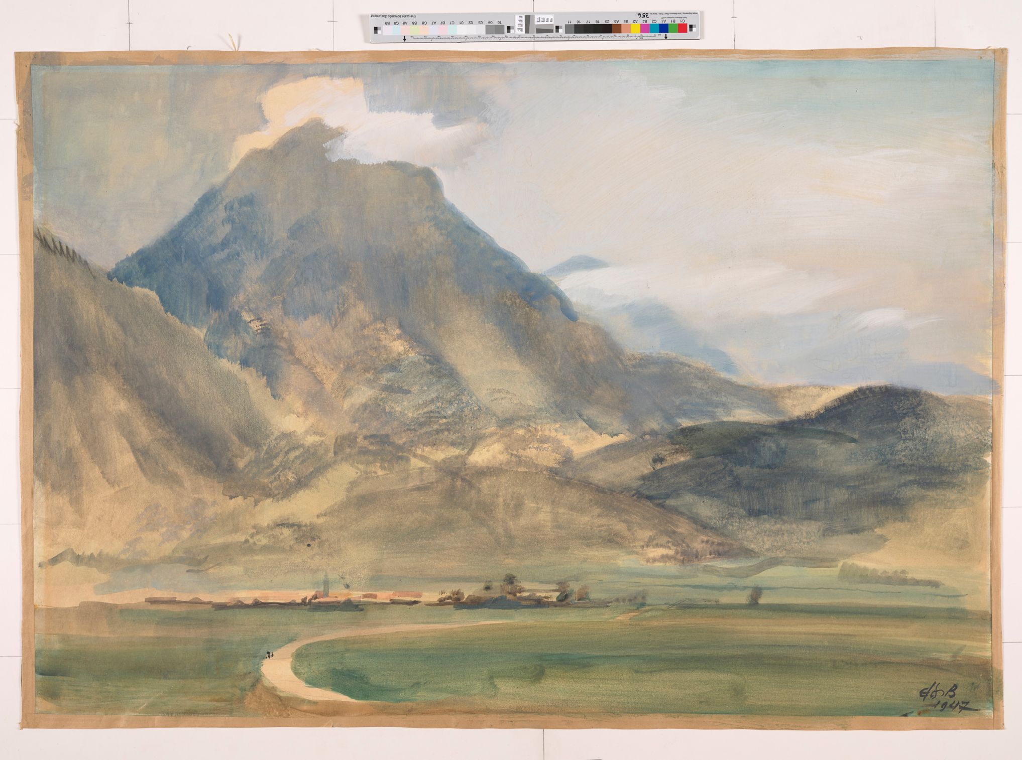 Eine Gebirgslandschaft mit einem kleinen Dorf und großen Hügeln.