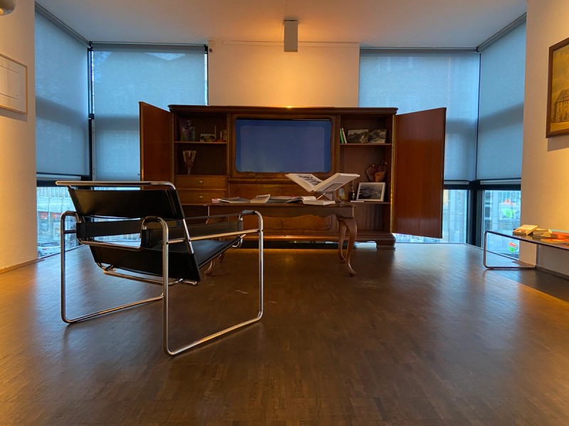 Stuhl vor einem geöffneten Schrank mit Fernseher