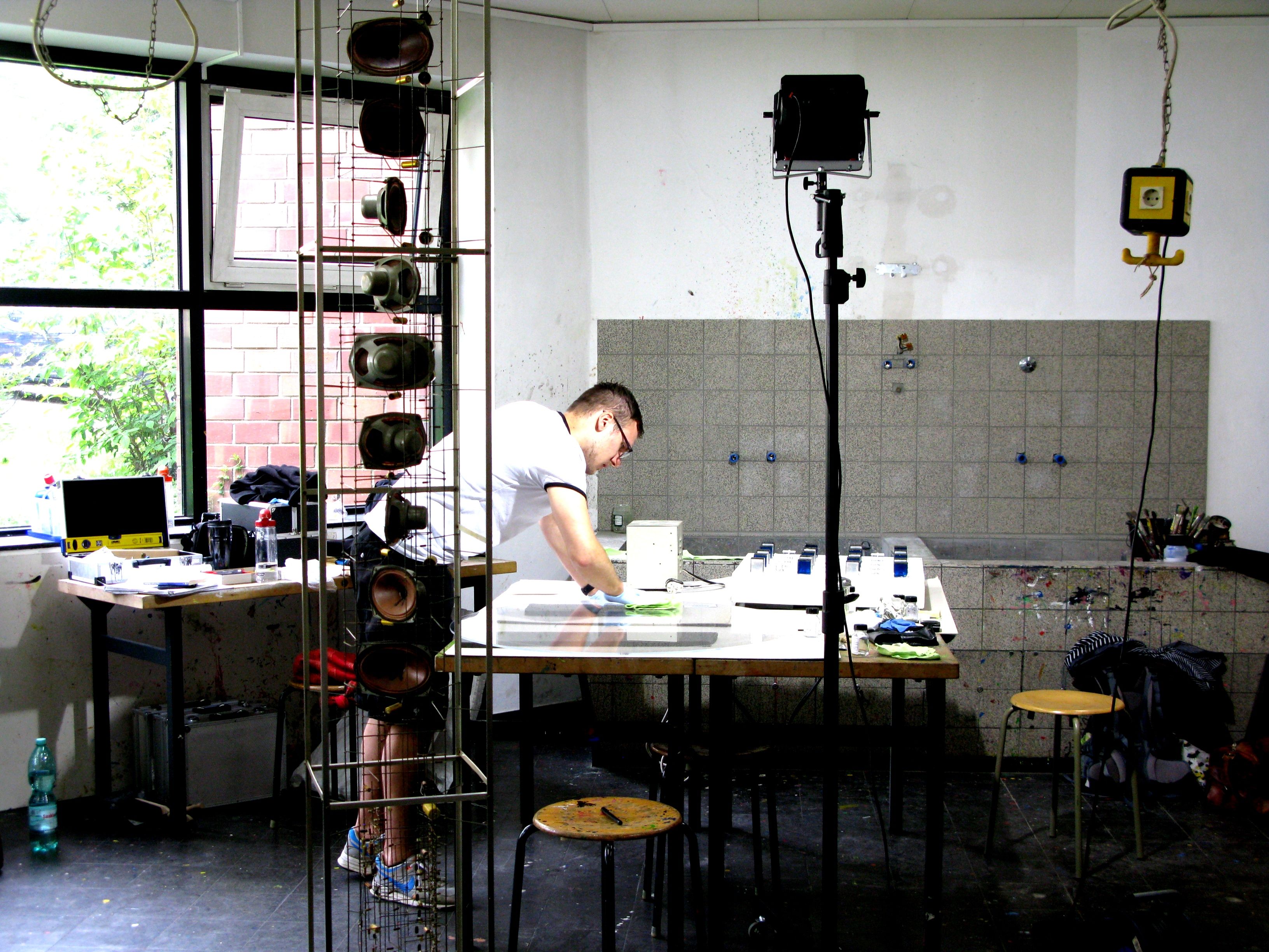 Restaurator über einen Tisch gebeugt. Lampe mit grellem Licht