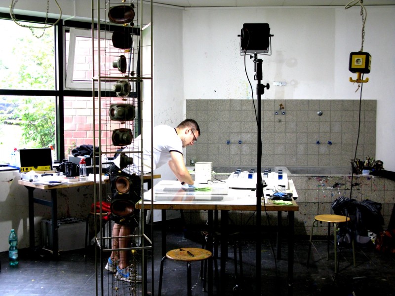 Restaurator über einen Tisch gebeugt. Lampe mit grellem Licht