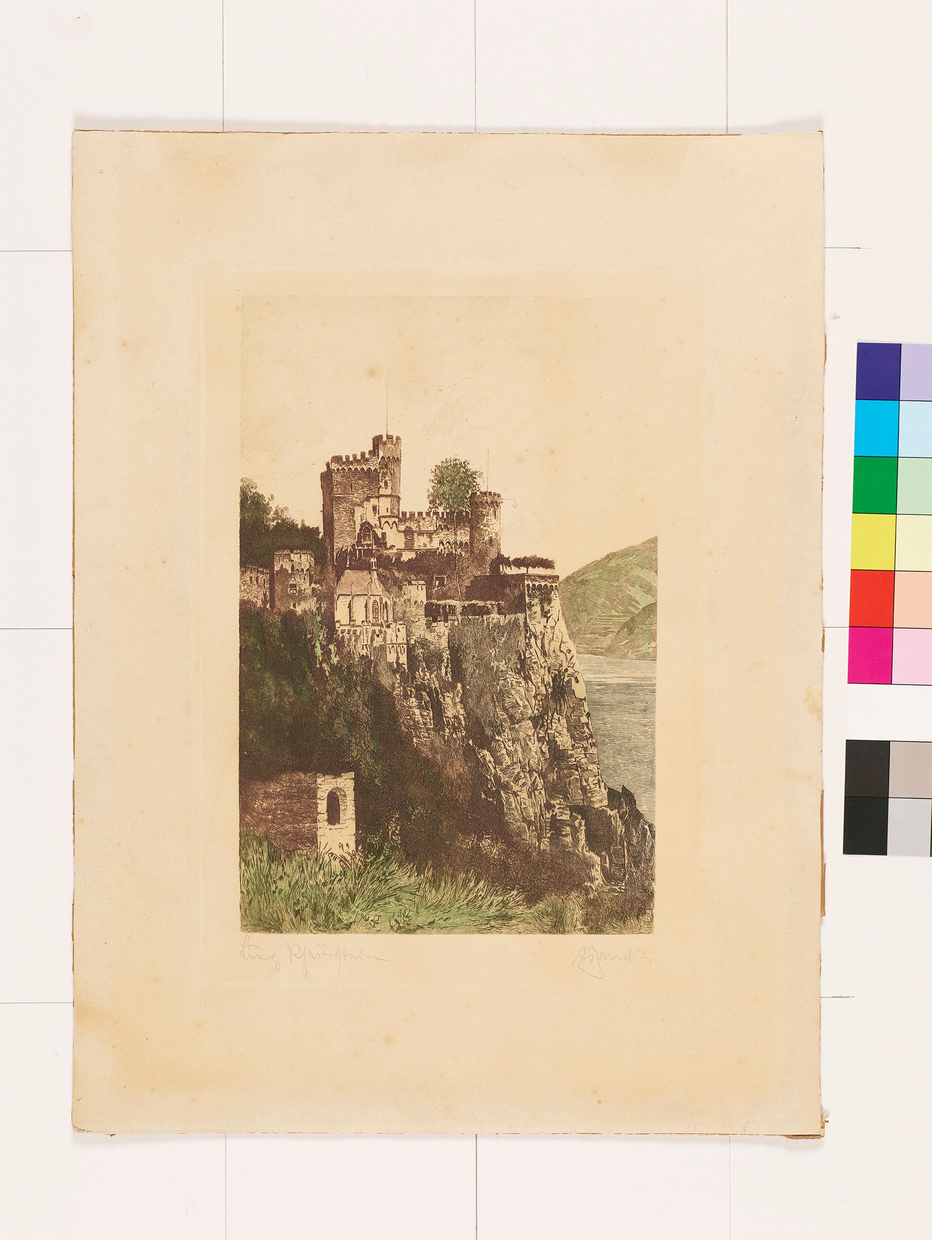 Eine Burg an einem Kliff aus der Ferne. Im Hintergrund sind Berge und Wasser.