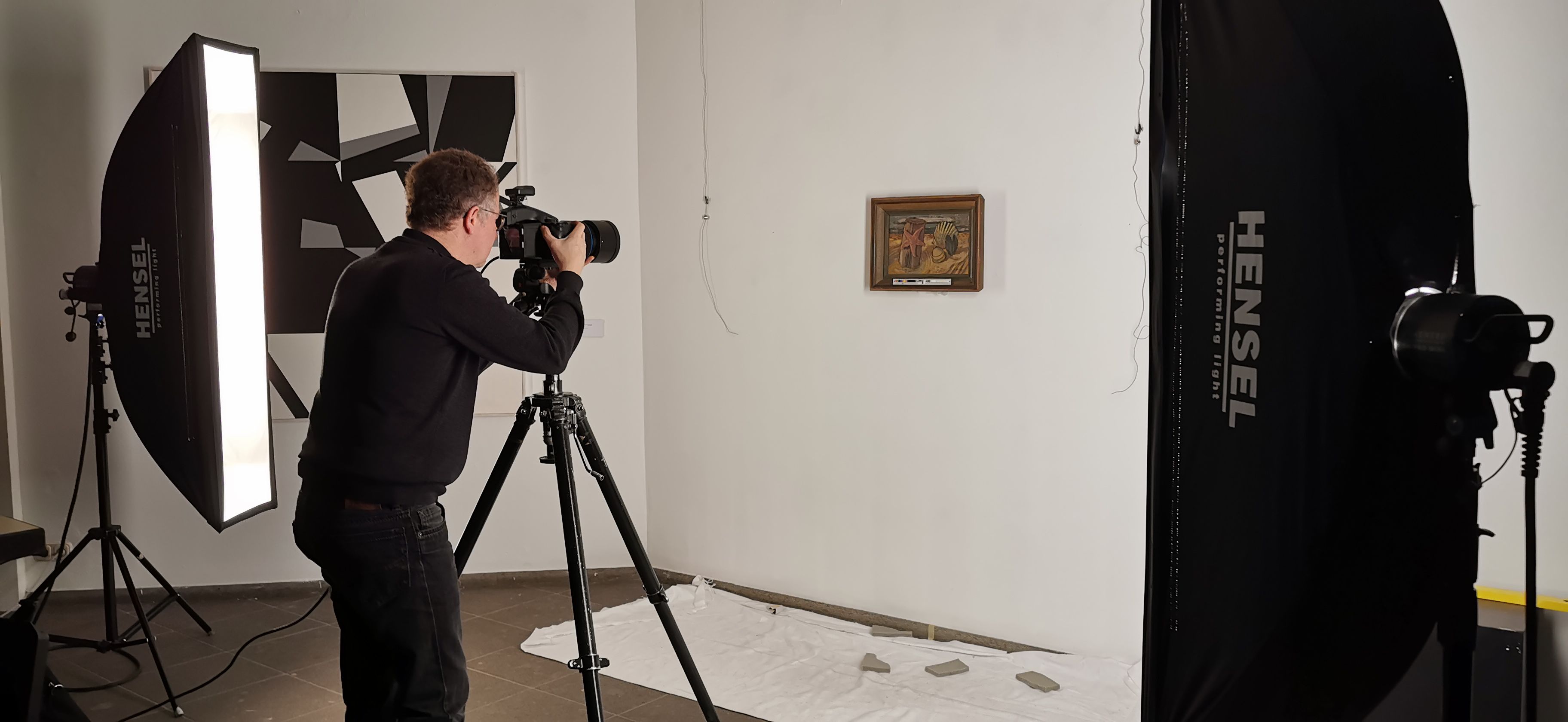 Fotograf mit Lampen vor Kunstwerk
