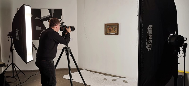 Fotograf mit Lampen vor Kunstwerk