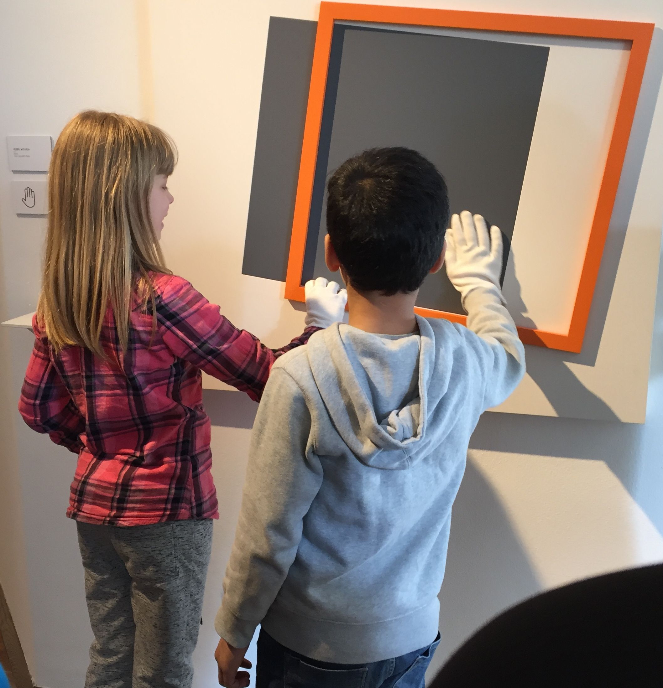 zwei Schüler*Innen an einem Kunstwerk zum Anfassen. 