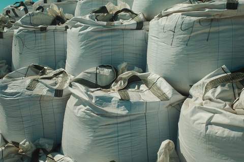Açık havada istiflenmiş beyaz büyük torbalar (big bag)