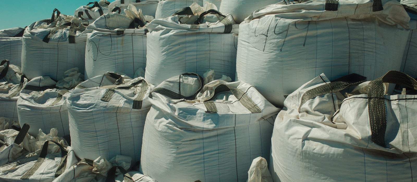 Açık havada istiflenmiş beyaz büyük torbalar (big bag)