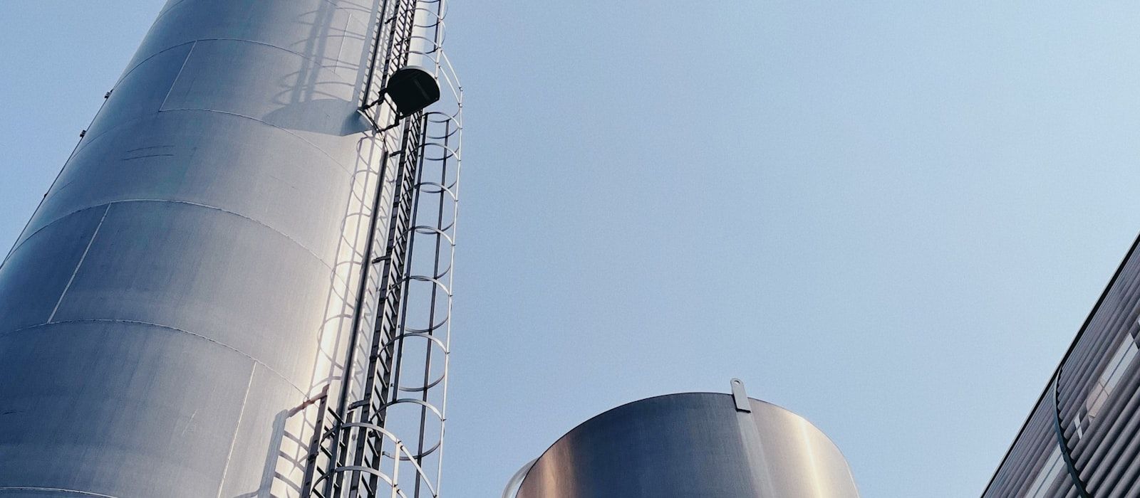 Gökyüzüne yükselen merdivenli endüstriyel metal silolar