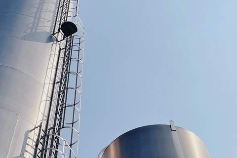 Gökyüzüne yükselen merdivenli endüstriyel metal silolar