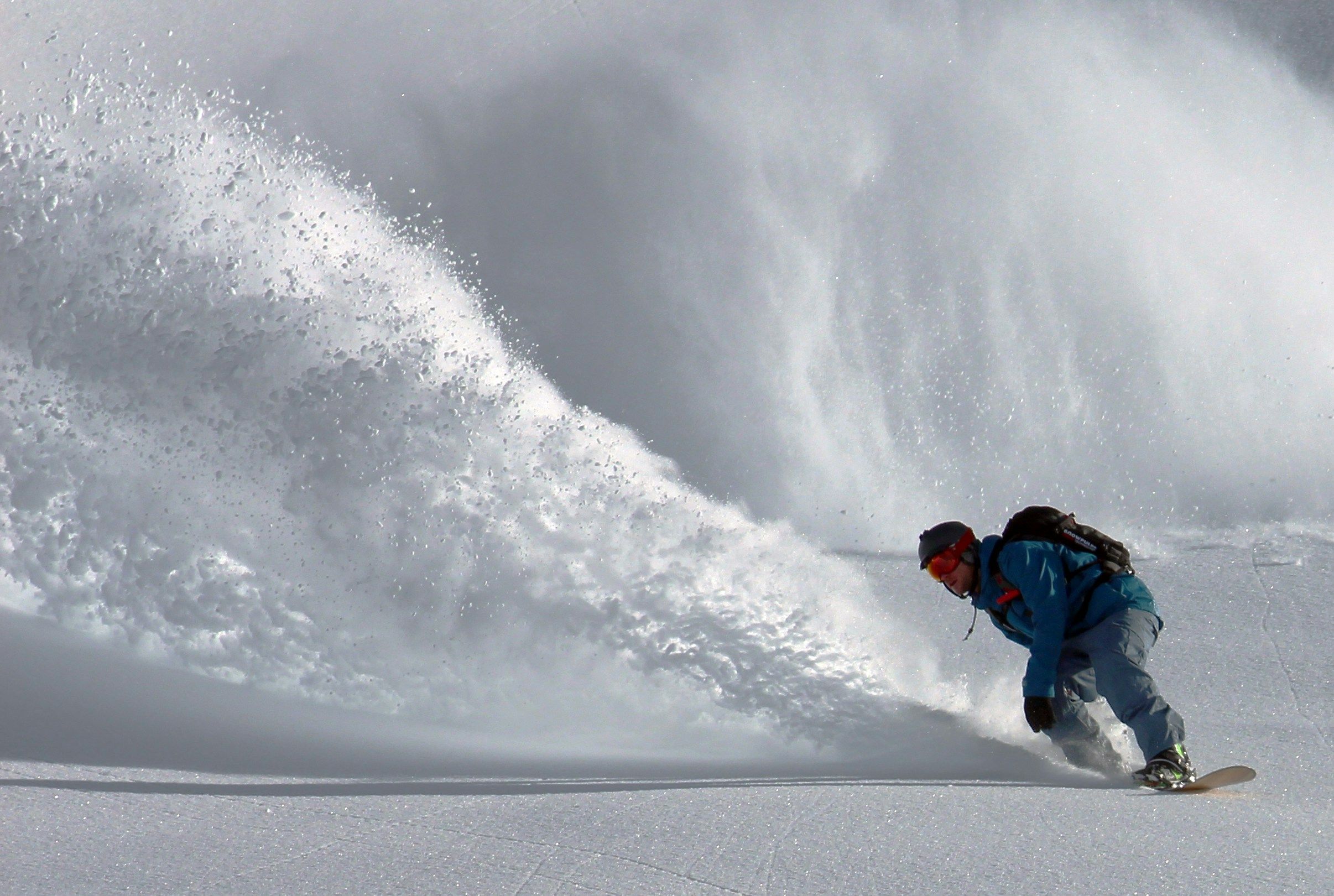Snowboarder in front of an avalanche 