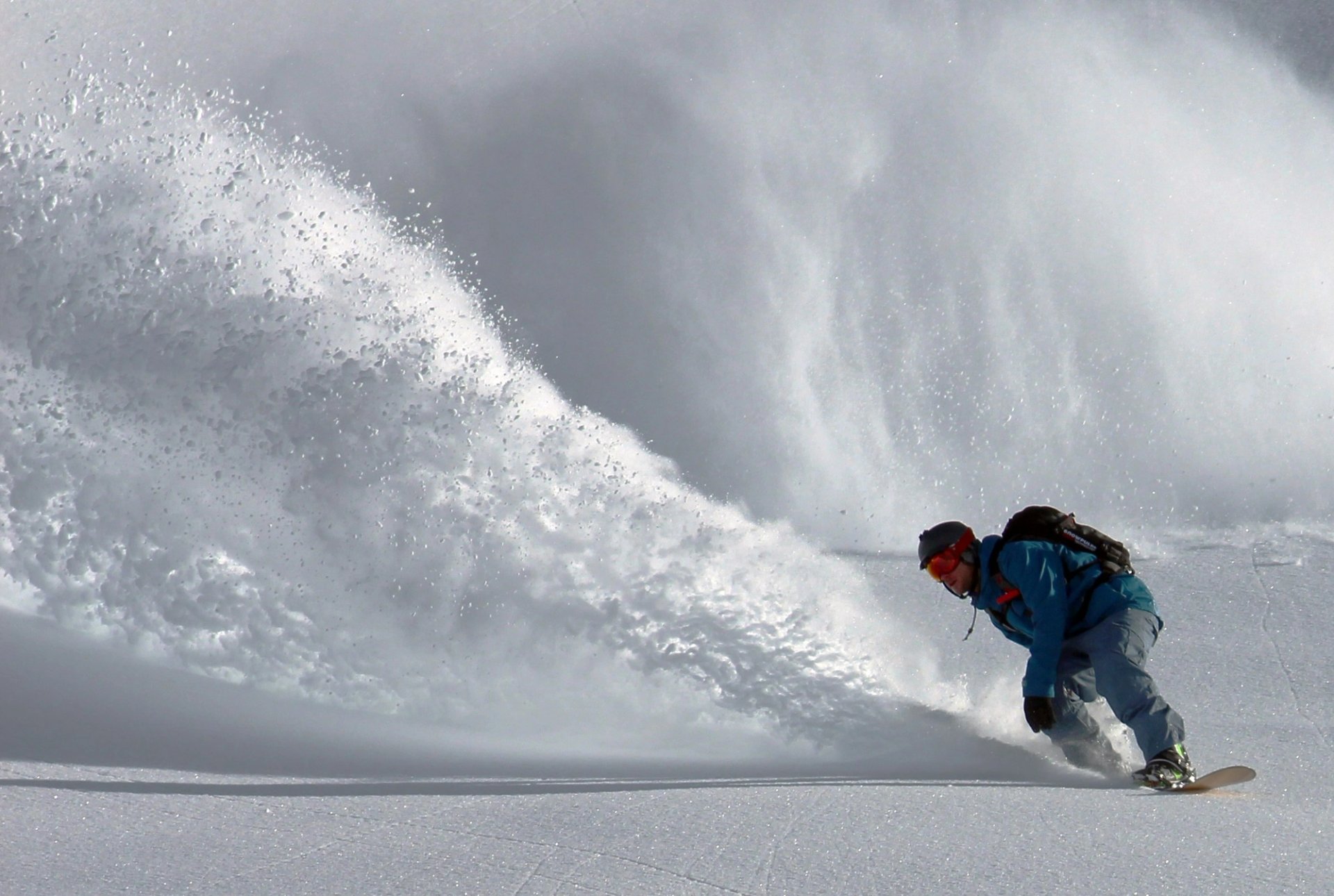 Snowboarder in front of an avalanche