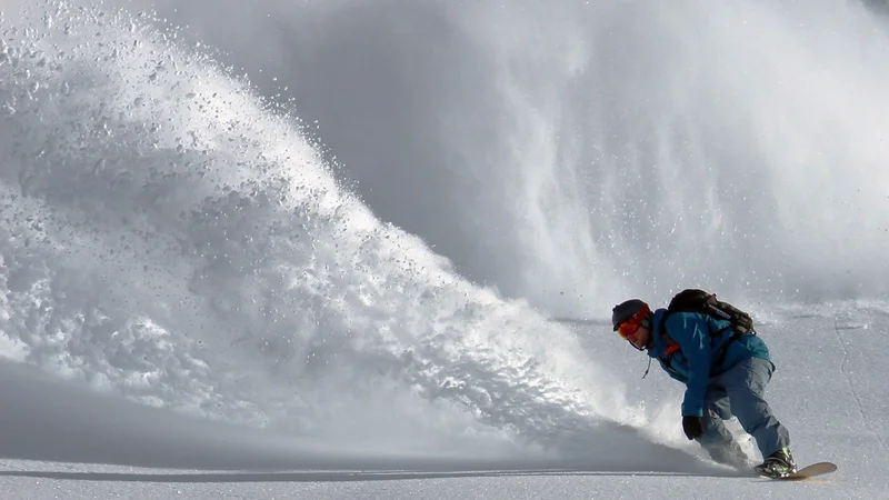 Snowboarder in front of an avalanche
