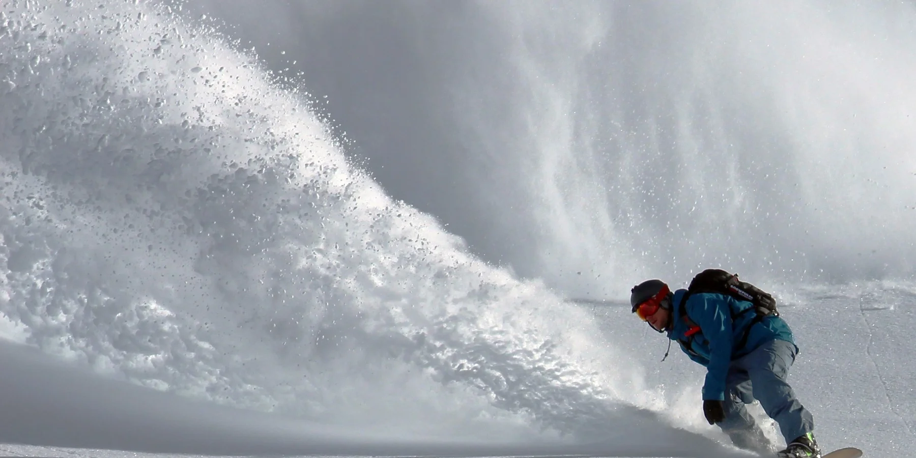 Snowboarder in front of an avalanche
