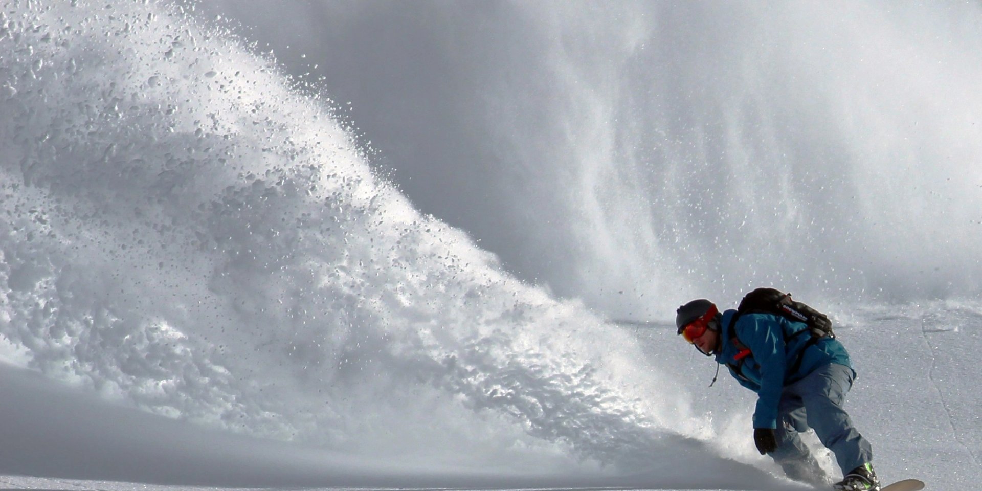 Snowboarder in front of an avalanche