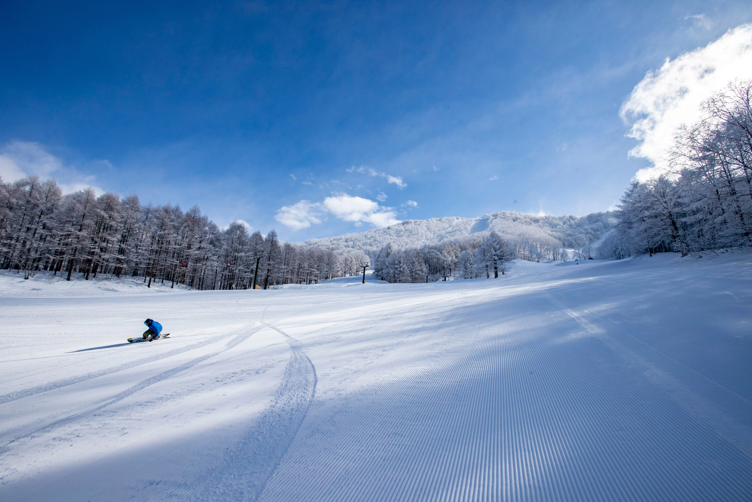 Snowboarder making turns on the corduroy
