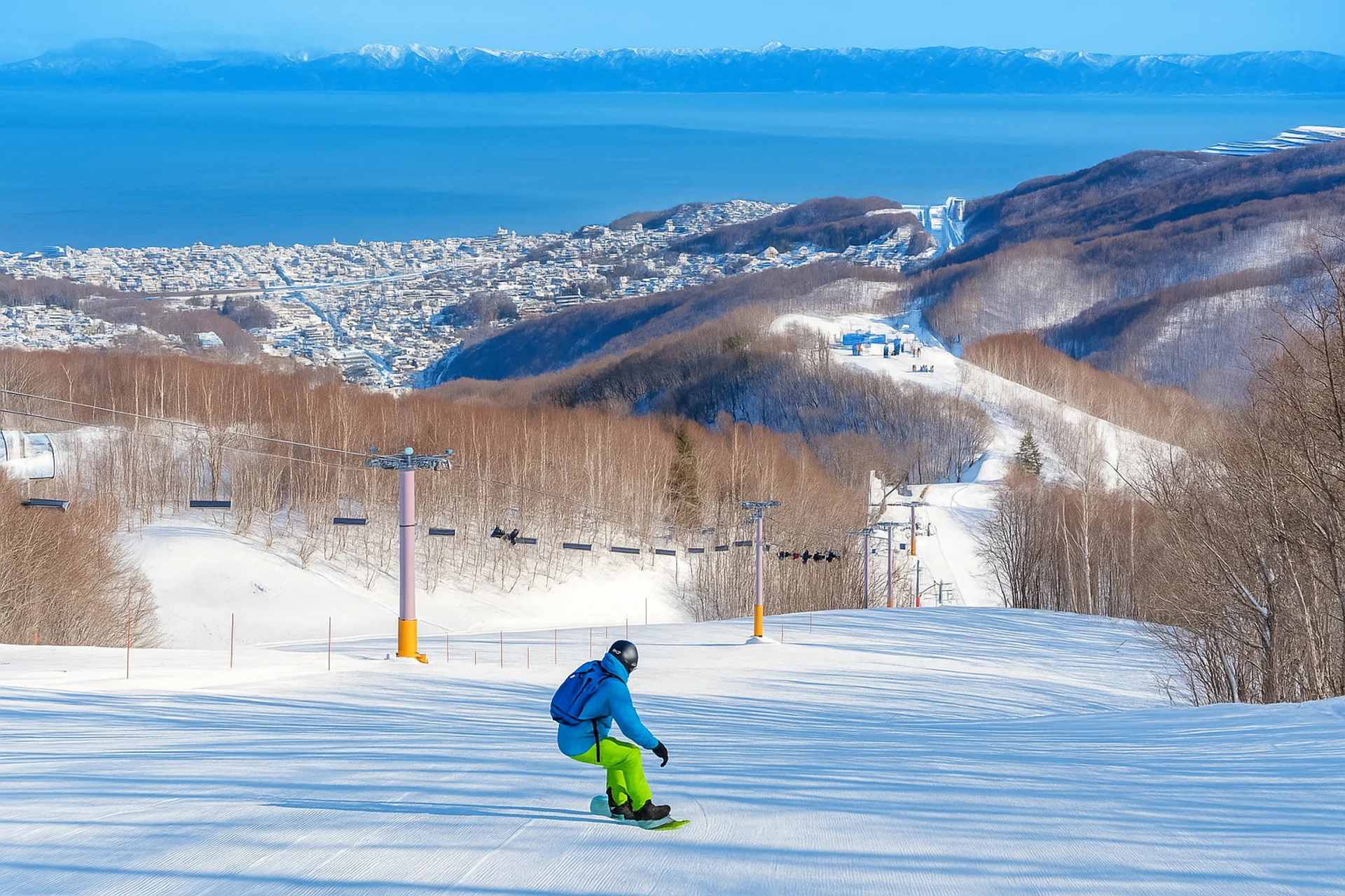snowboarder flying down a intermediate run looking over Otaru and ocean