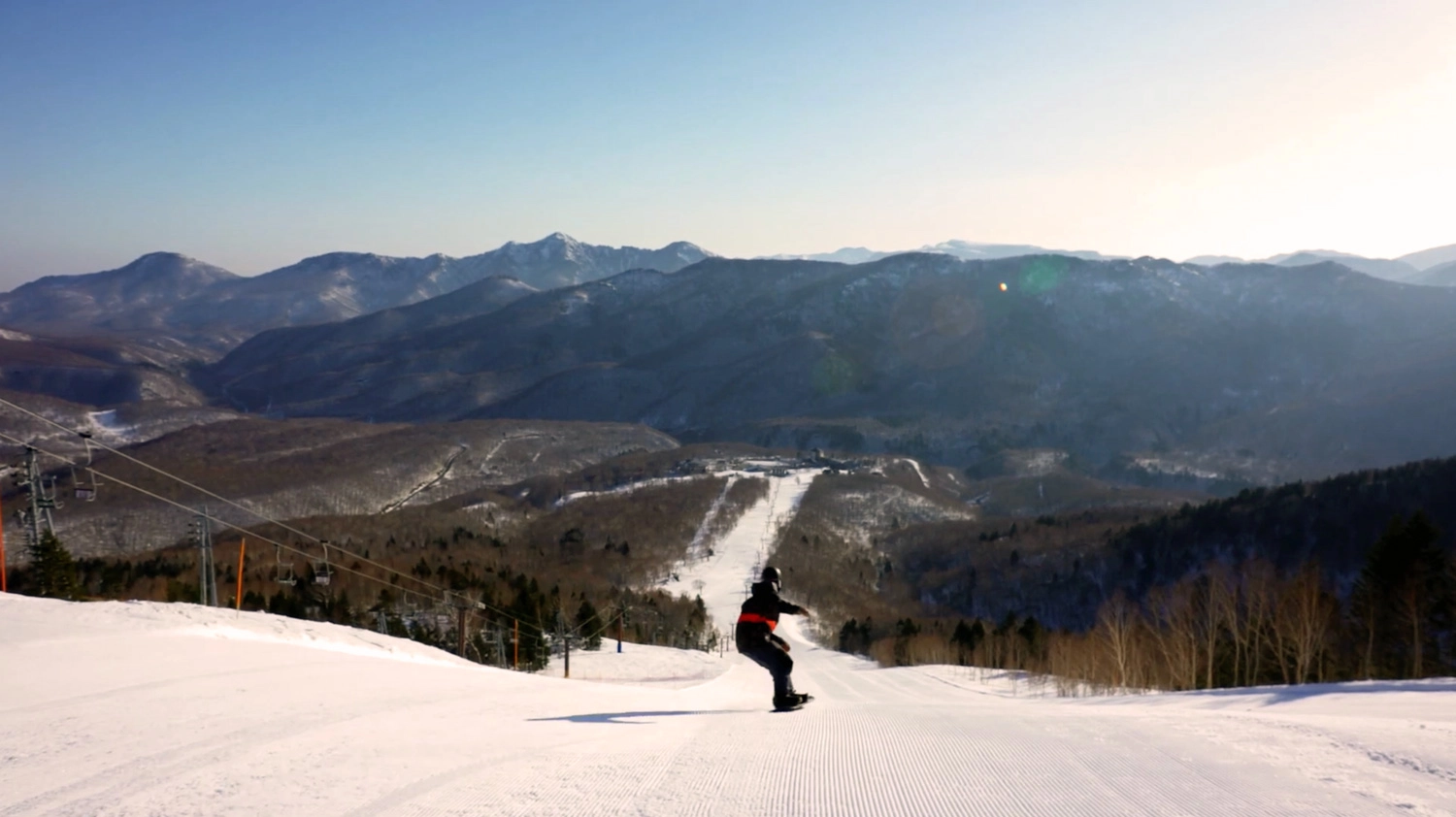 Snowboarder on a long groomed run at Okushiga Kogen