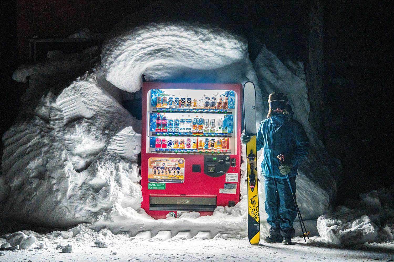Skier by a vending machine in the snow