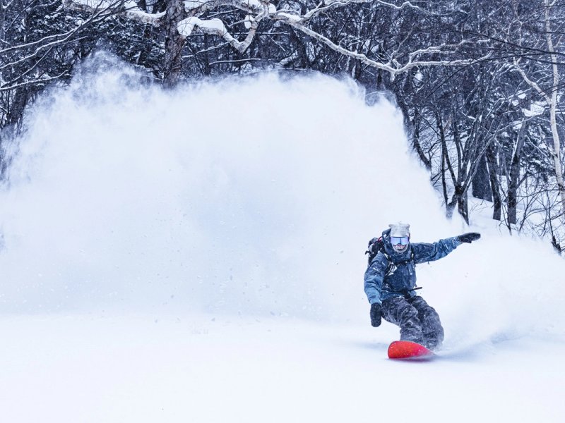 Snowboarder enjoying backcountry pow in Aomori