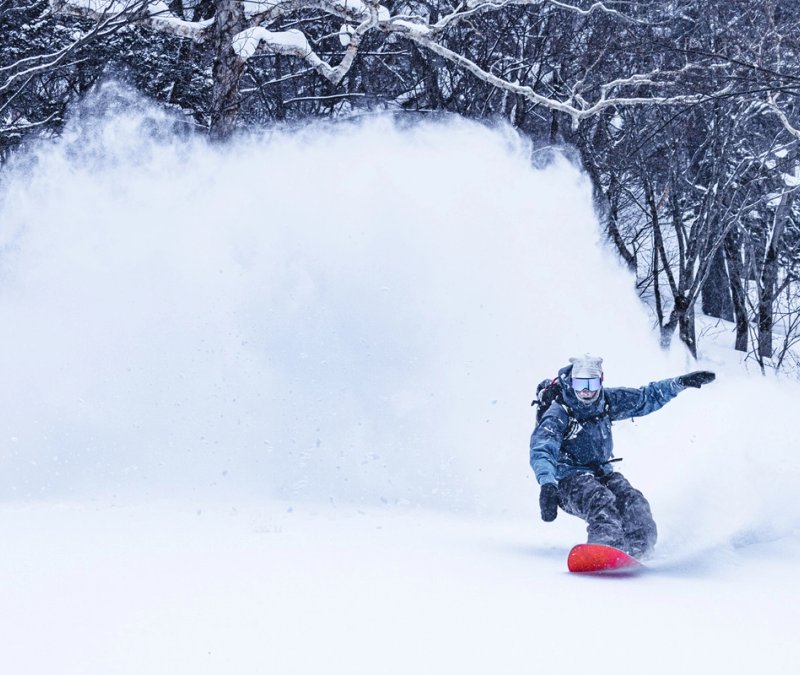 Snowboarder enjoying backcountry pow in Aomori