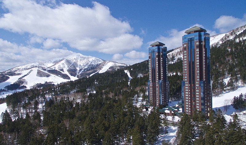 Views of hotel towers in front of ski runs in the background