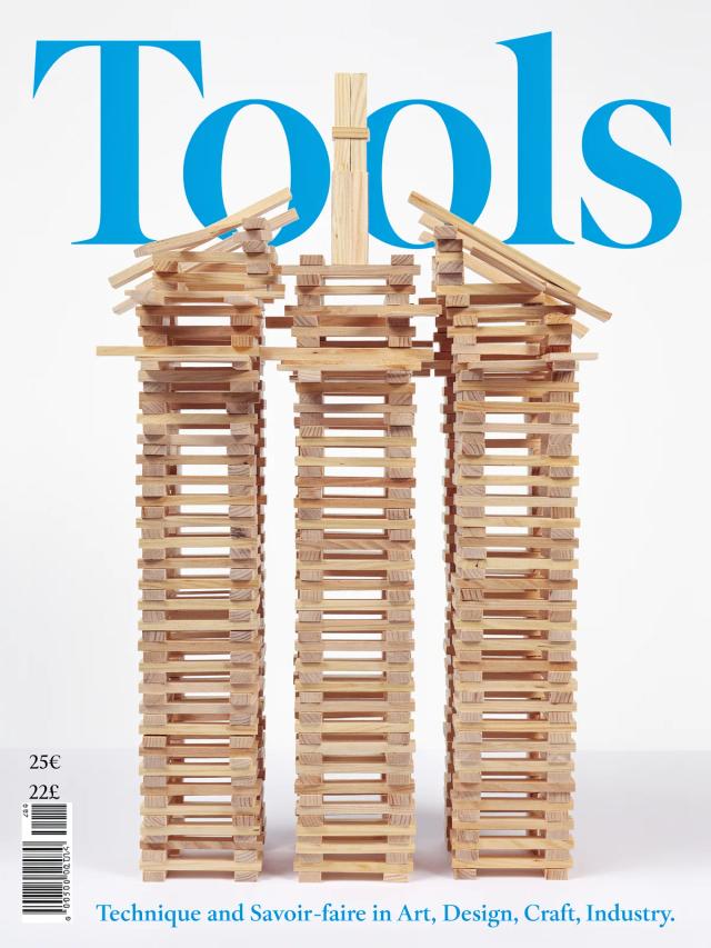 Magazine cover with a large headline set over stacked wooden towers