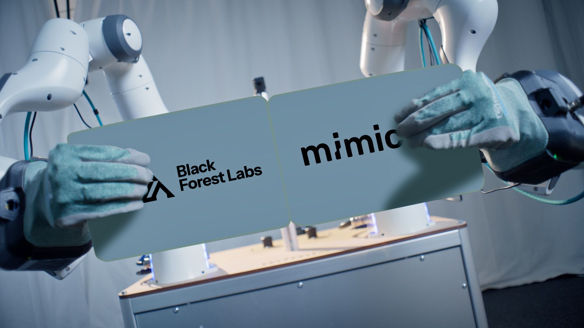 FLUX 3와 mimic 로봇 팔이 공장 작업대 부품을 집는 장면을 보여주는 공식 이미지
