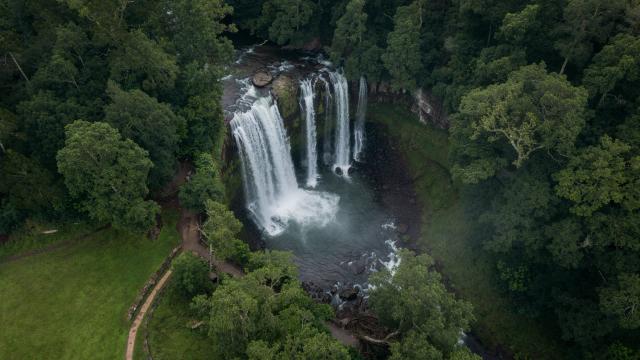 Wide aerial landscape of a waterfall in dense forest