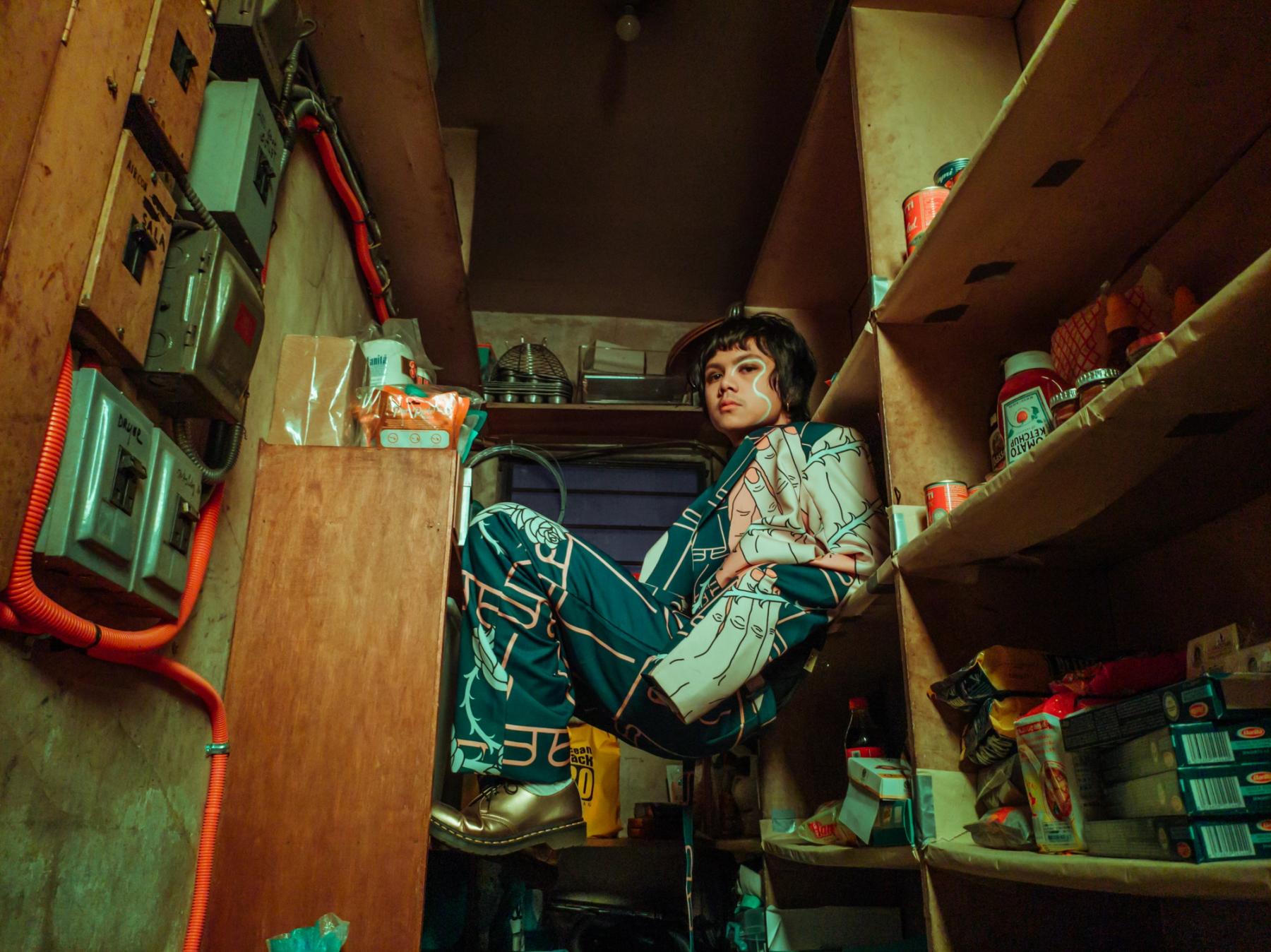 Zild is perched between pantry shelves in a greenish light