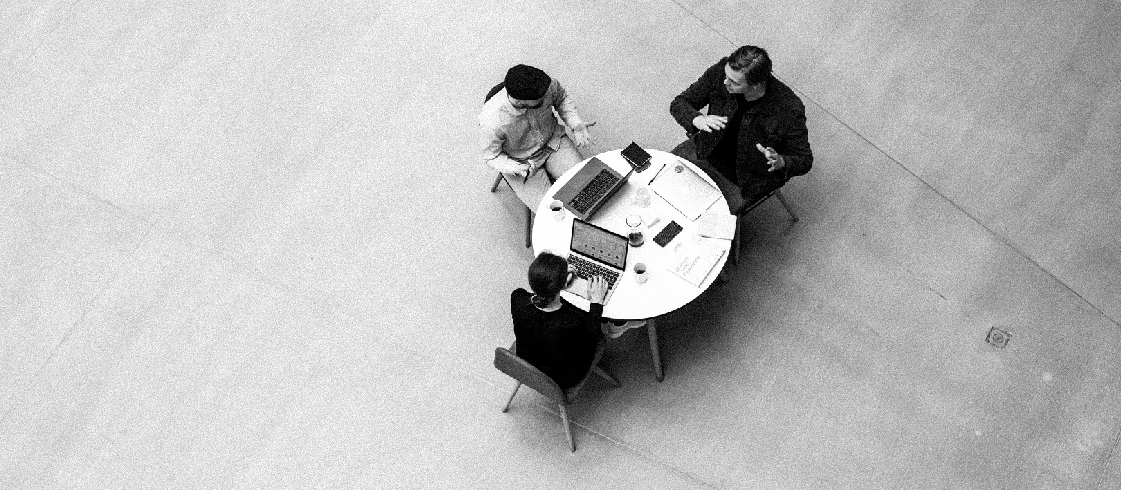3 people having a meeting in the middle of a large room