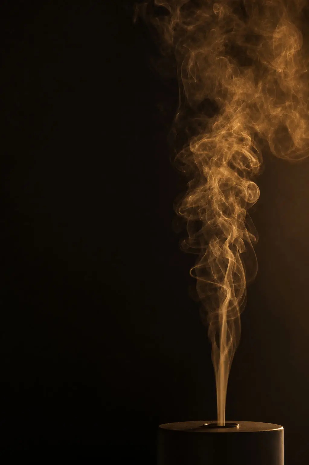 Amber fragrance mist rising over a dark backdrop