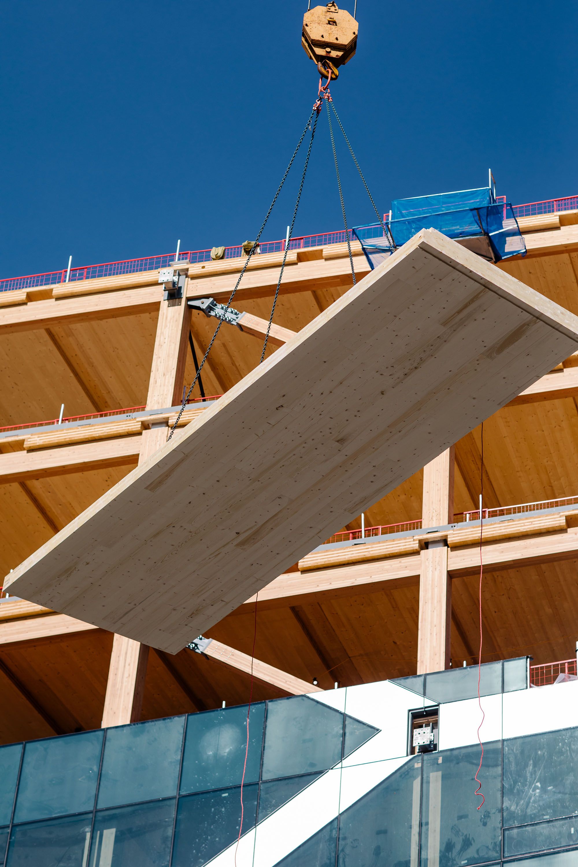 Mass timber panel being raised by crane during building construction