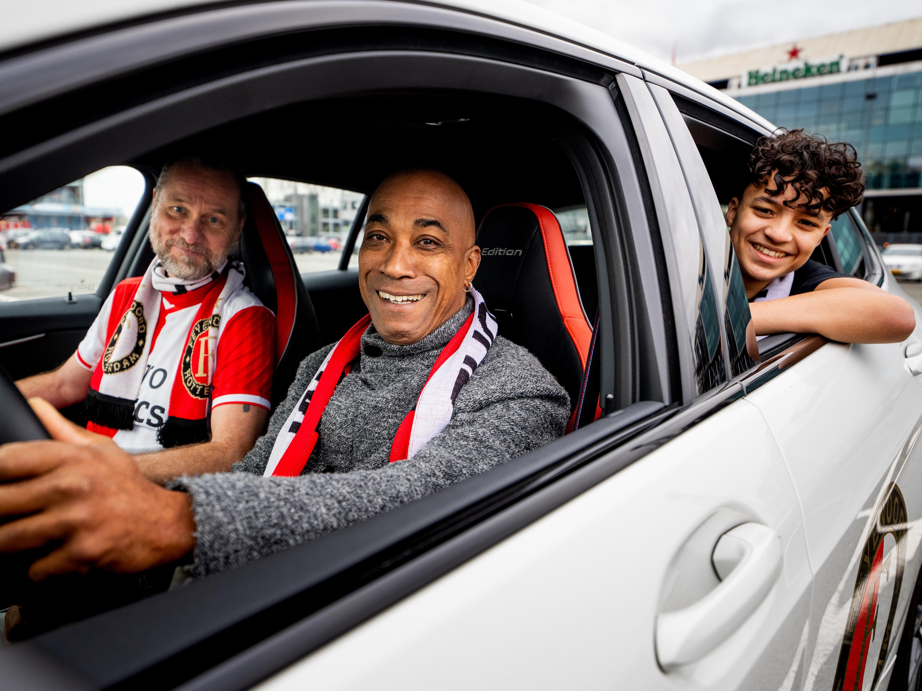 Afbeelding van drie Feyenoord-supporters in een auto voor De Kuip (Feijenoord Stadion)