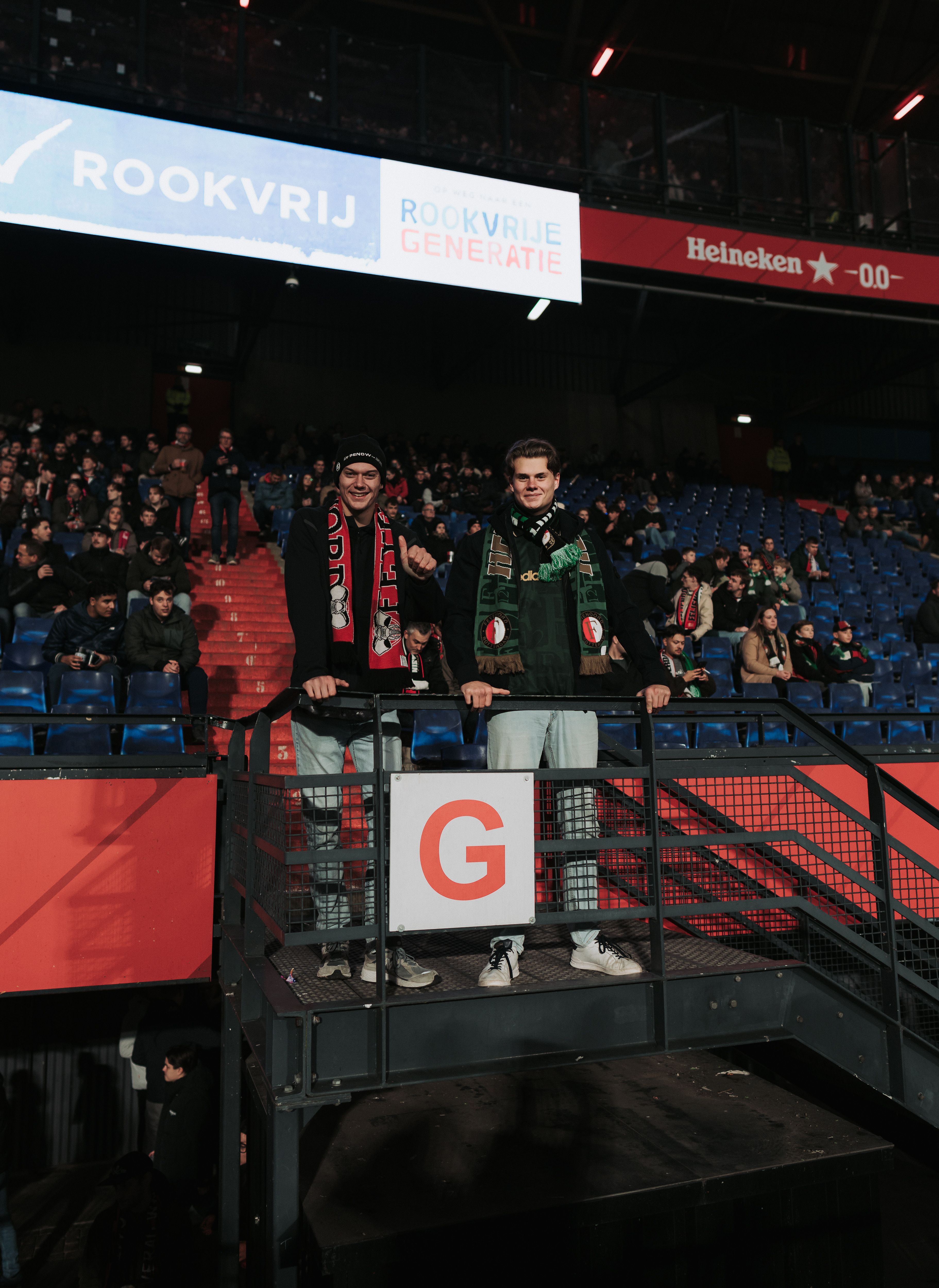 Twee supporters in De Kuip onder een uiting van een Rookvrije Generatie