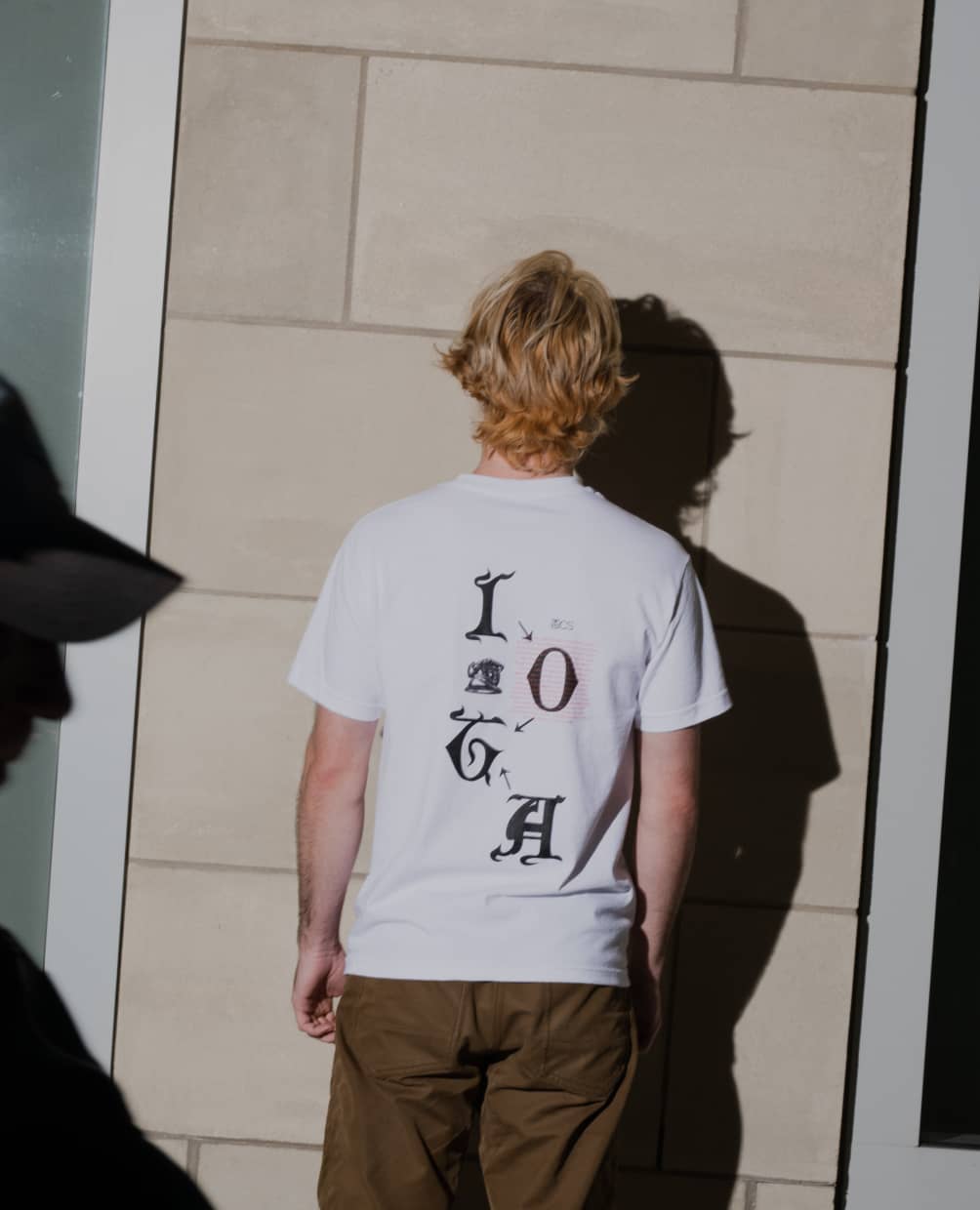 Man wearing ALLCAPS x IOTA shirt