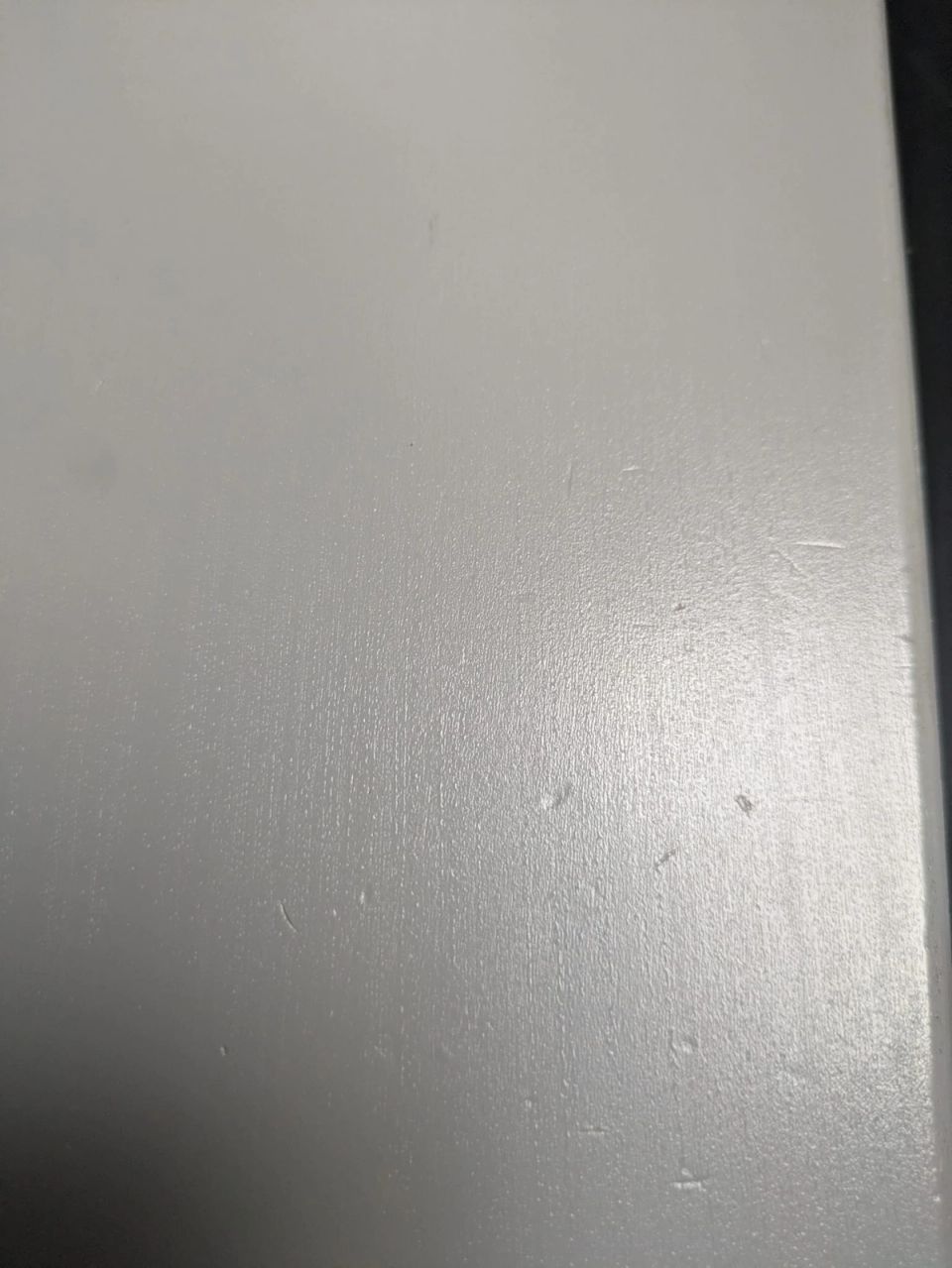 Surface scratches and small signs of use in the hard painted finish of a grey Stokke Tripp Trapp