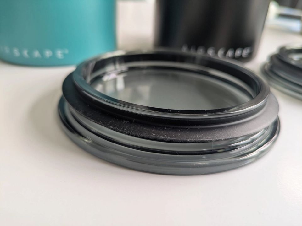 Close-up of a transparent Airscape outer lid with dust and lint around its dark rim.