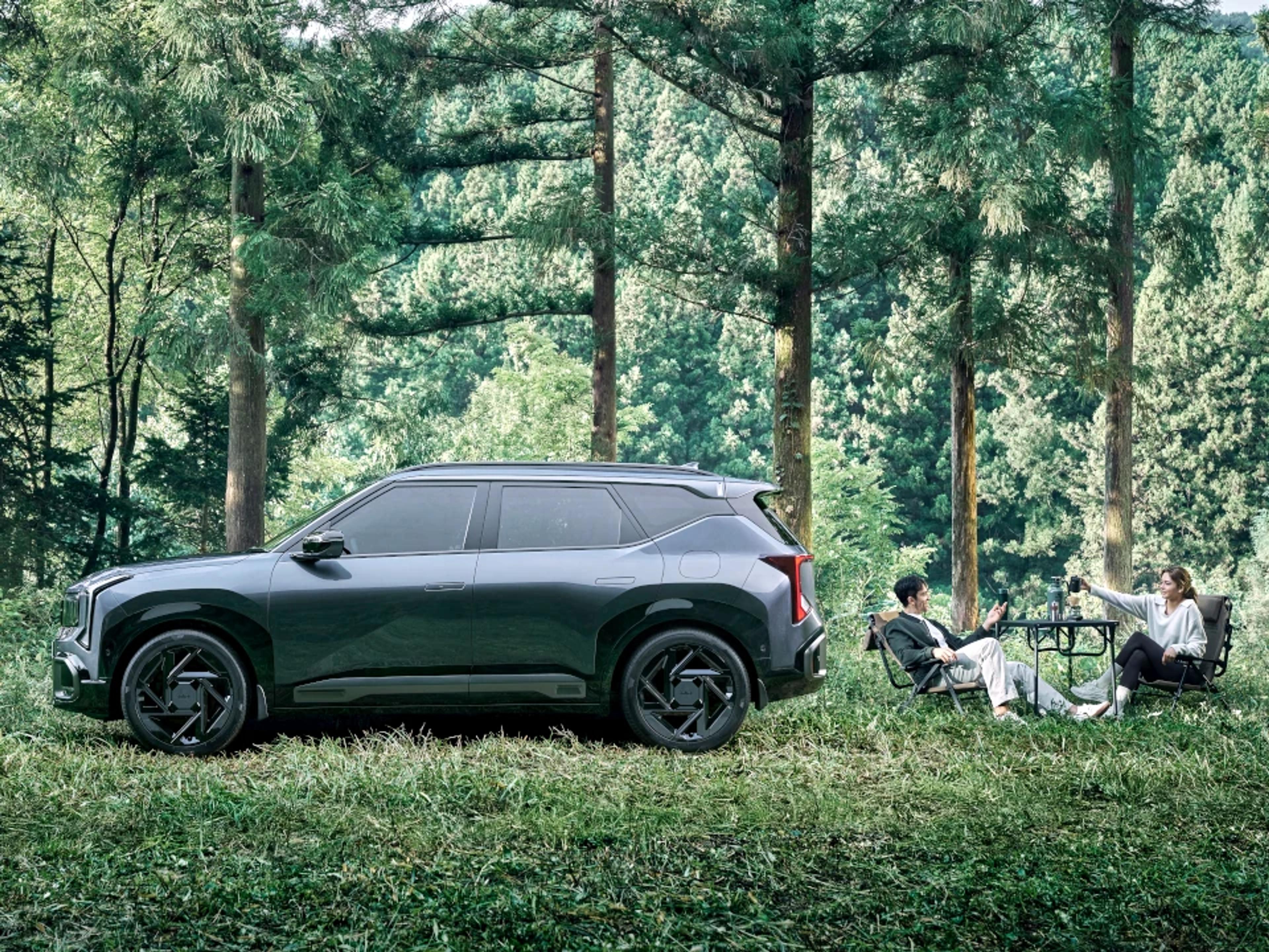 2027 Kia Seltos hybrid small SUV side profile parked in a forest