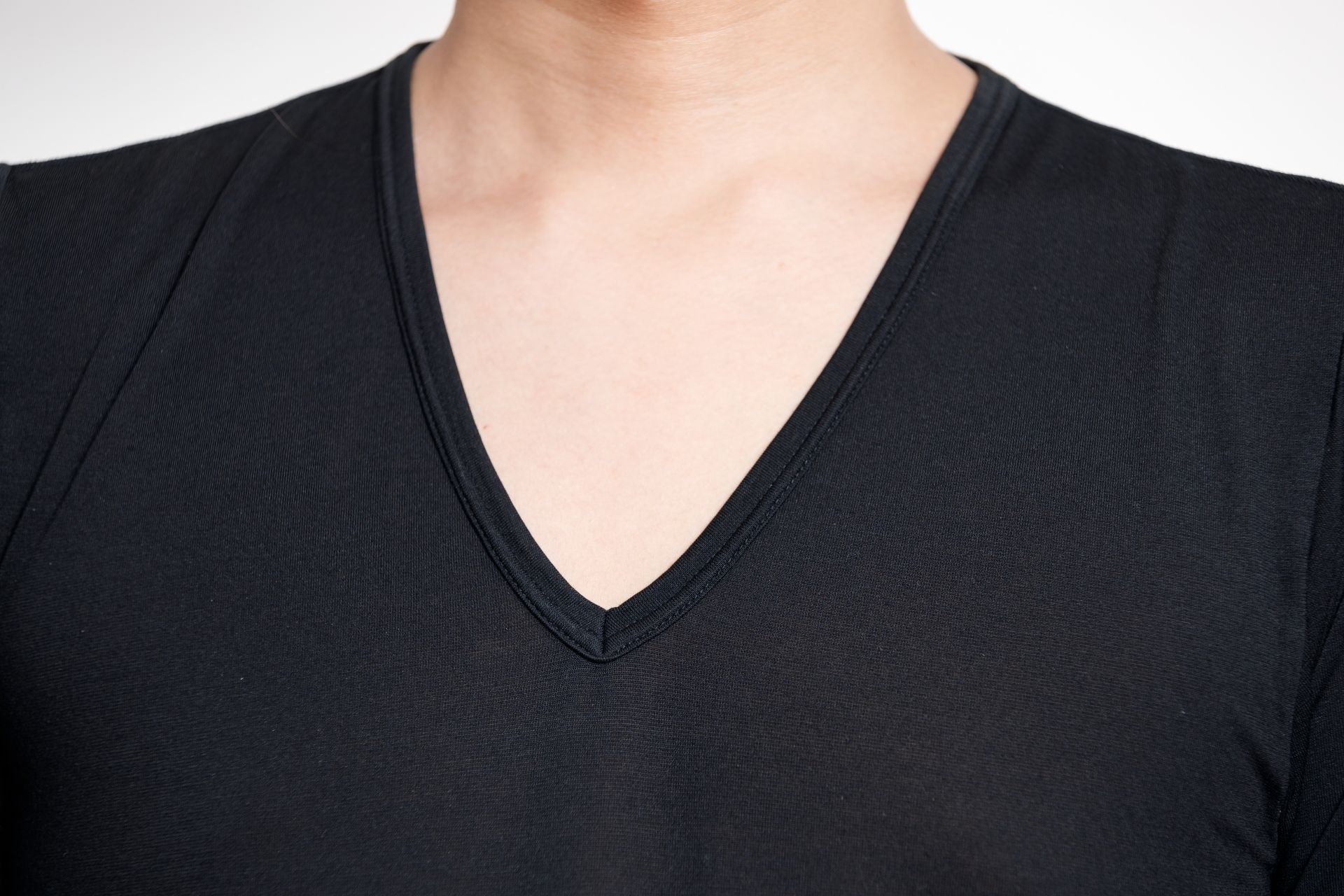 A person wearing a black V-neck shirt.