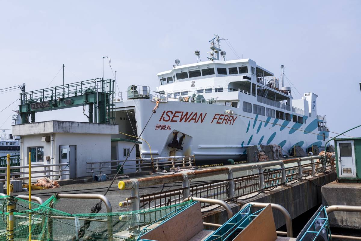 A large white ferry boat named "ISEWAN FERRY" docked at a pier under a clear sky.