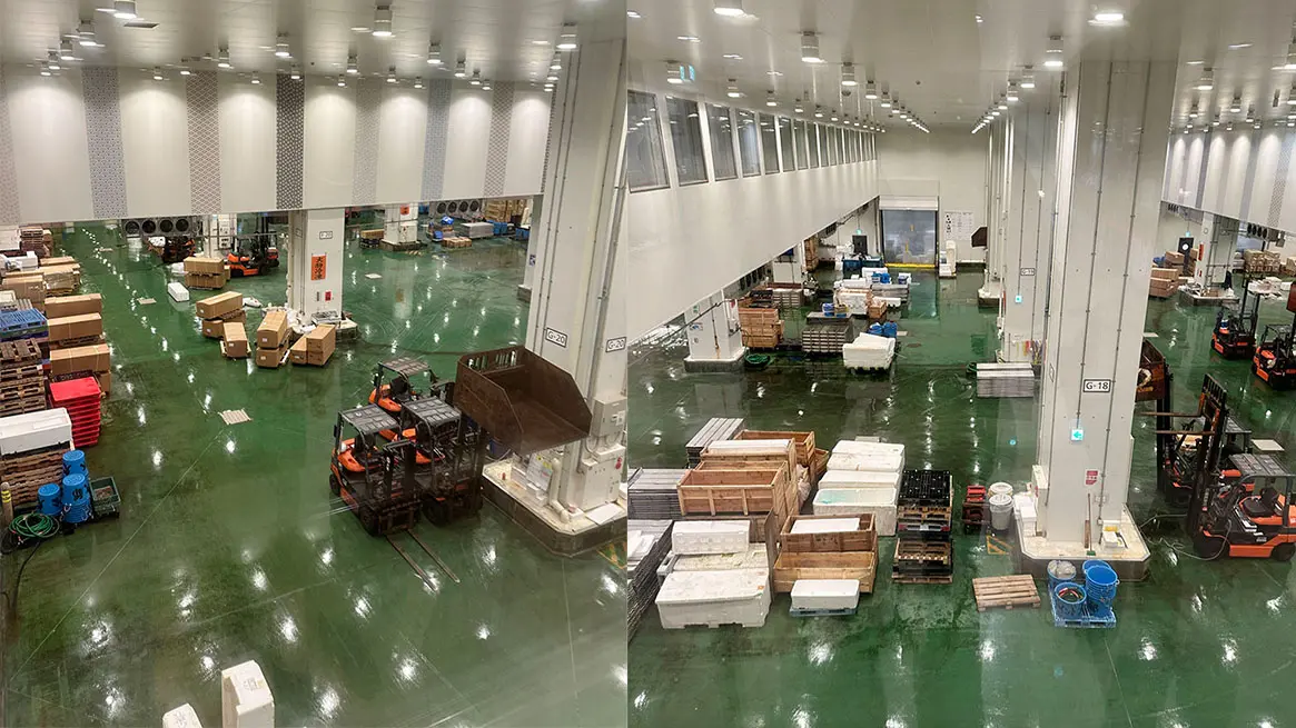 Brightly lit industrial warehouse with a wet green floor, forklifts, and storage containers.