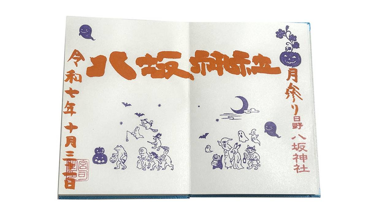 An open book or paper with Japanese Halloween-themed text in orange and purple, surrounded by illustrations of ghosts