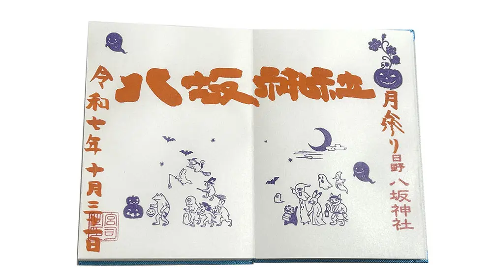 An open book or paper with Japanese Halloween-themed text in orange and purple, surrounded by illustrations of ghosts