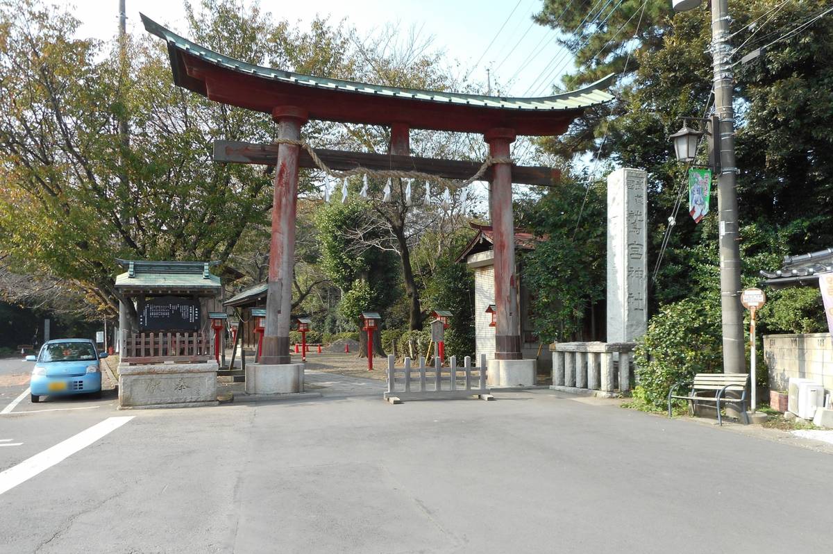A large red torii gate marks the entrance to a Shinto shrine