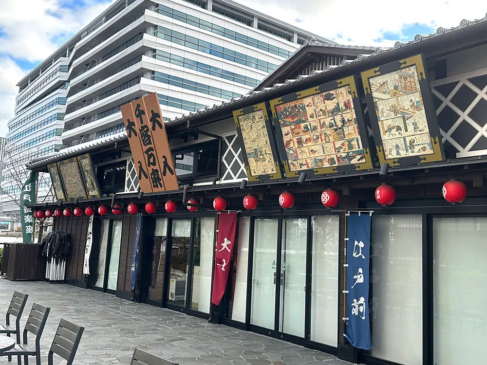 A traditional Japanese building with decorative ukiyo-e prints and red lanterns