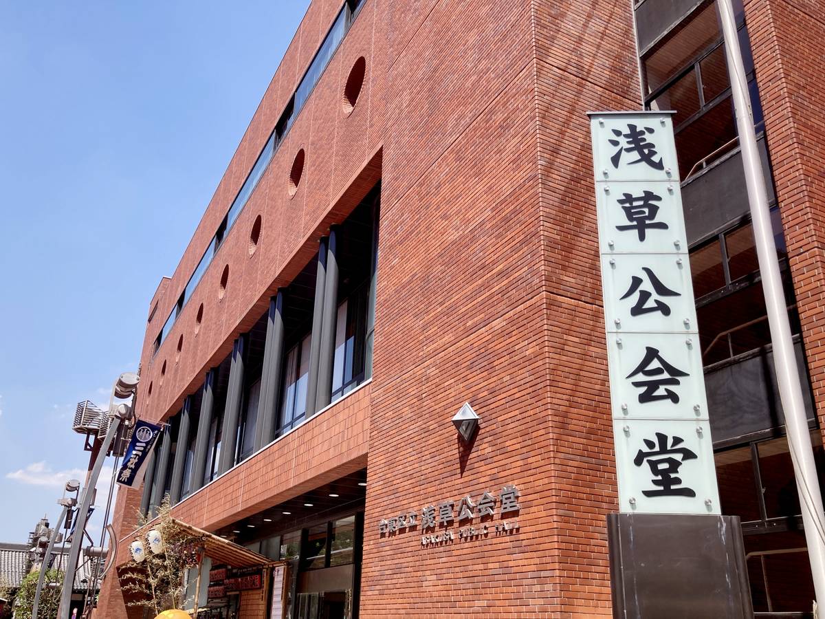 A red brick building with a vertical sign reading "Asakusa Public Hall" in Japanese characters.