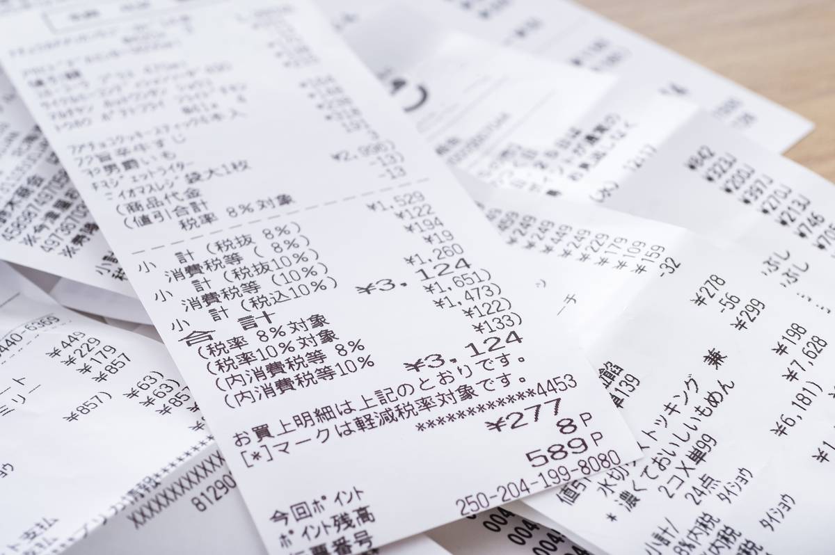 Scattered Japanese shopping receipts showing item details and prices.